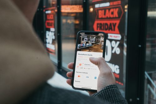 Digitale Transformation des stationären Handels: Kunde schaut sich Informationen zum Laden vorab auf dem Smartphone an
