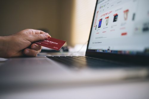 Frau stöbert auf Ebay und hält Kreditkarte bereit